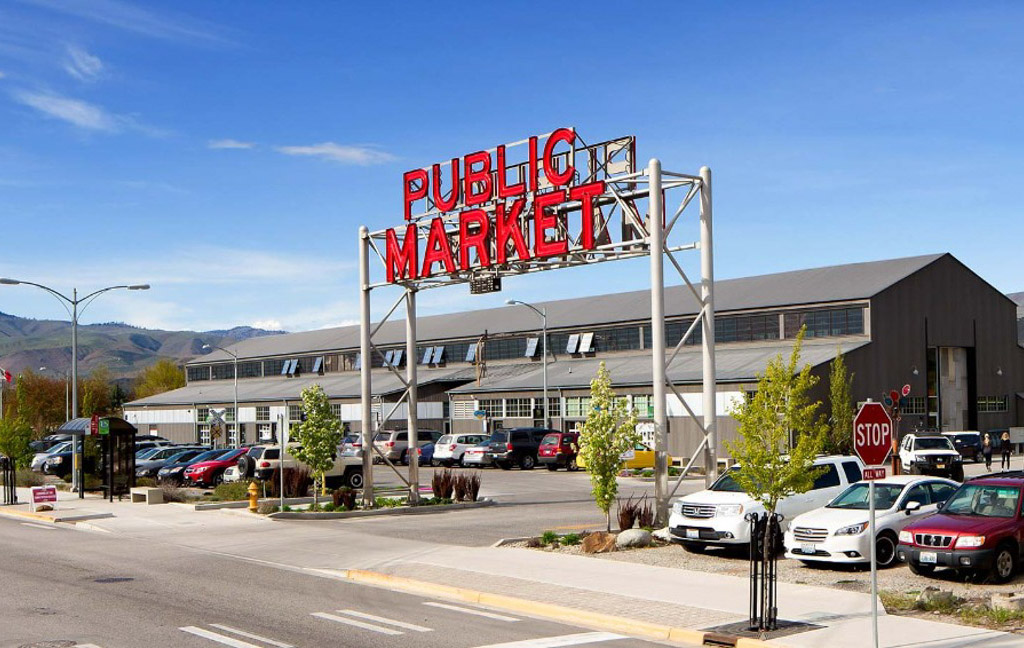 Public market with parking lot and mountains.