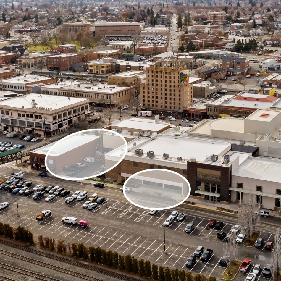 Aerial view of city buildings and parking lots.