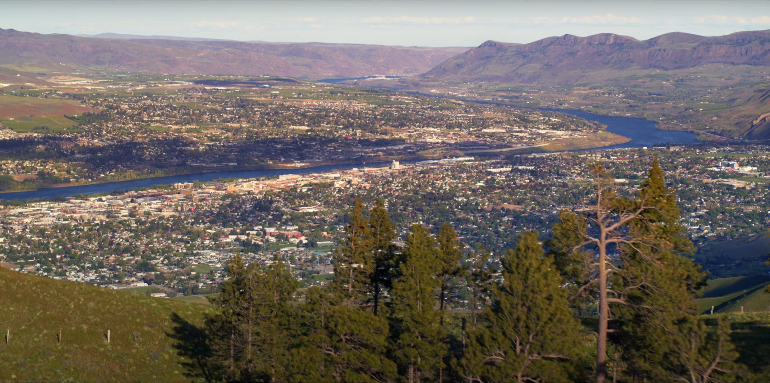 Aerial view of city with river and hills