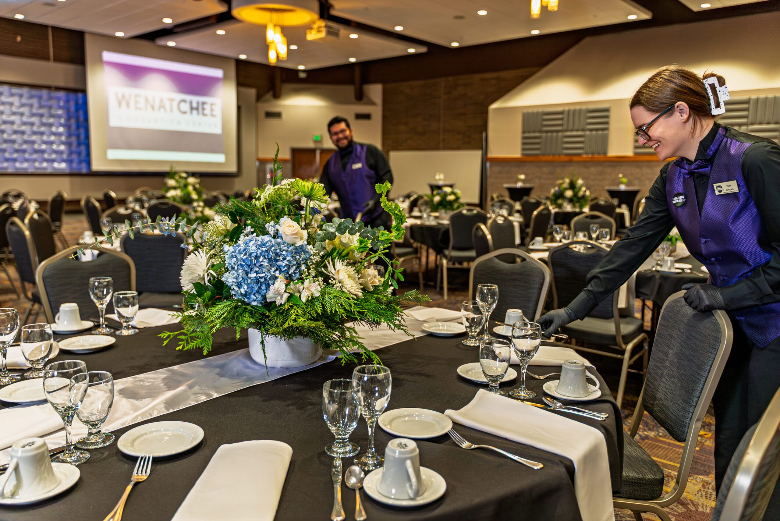 Tables with elegant floral centerpieces at an event.
