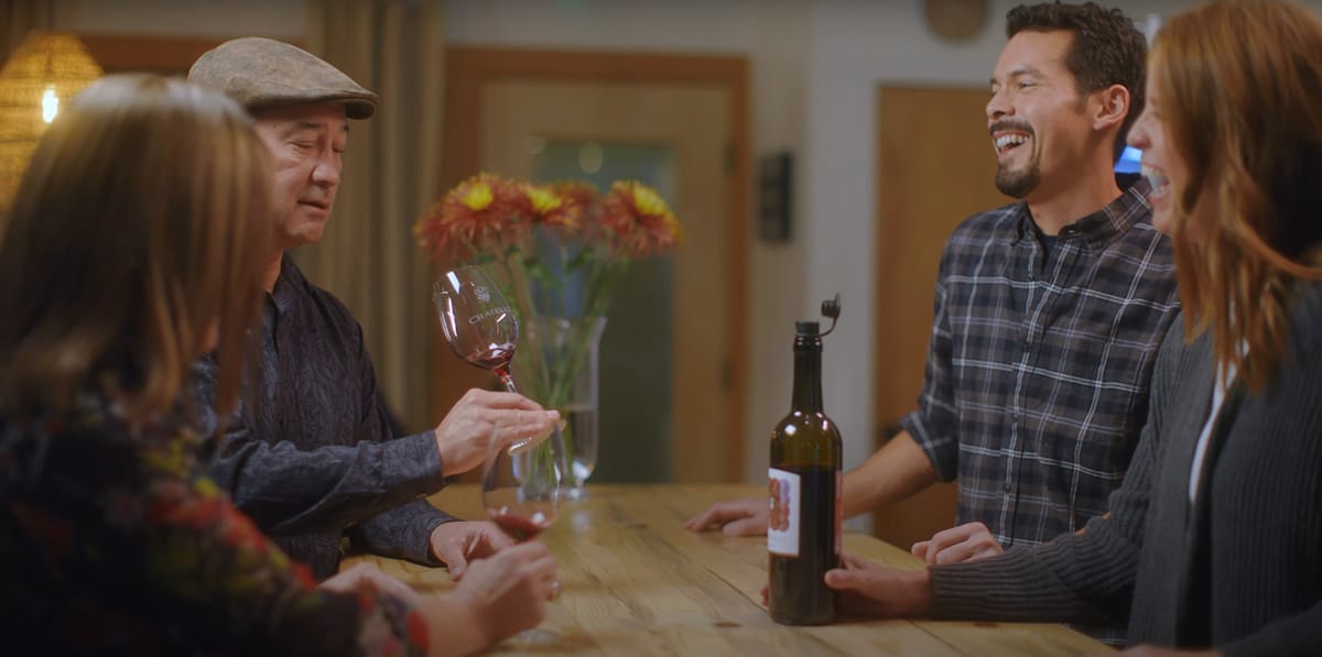 Group of people enjoying wine together at a table.