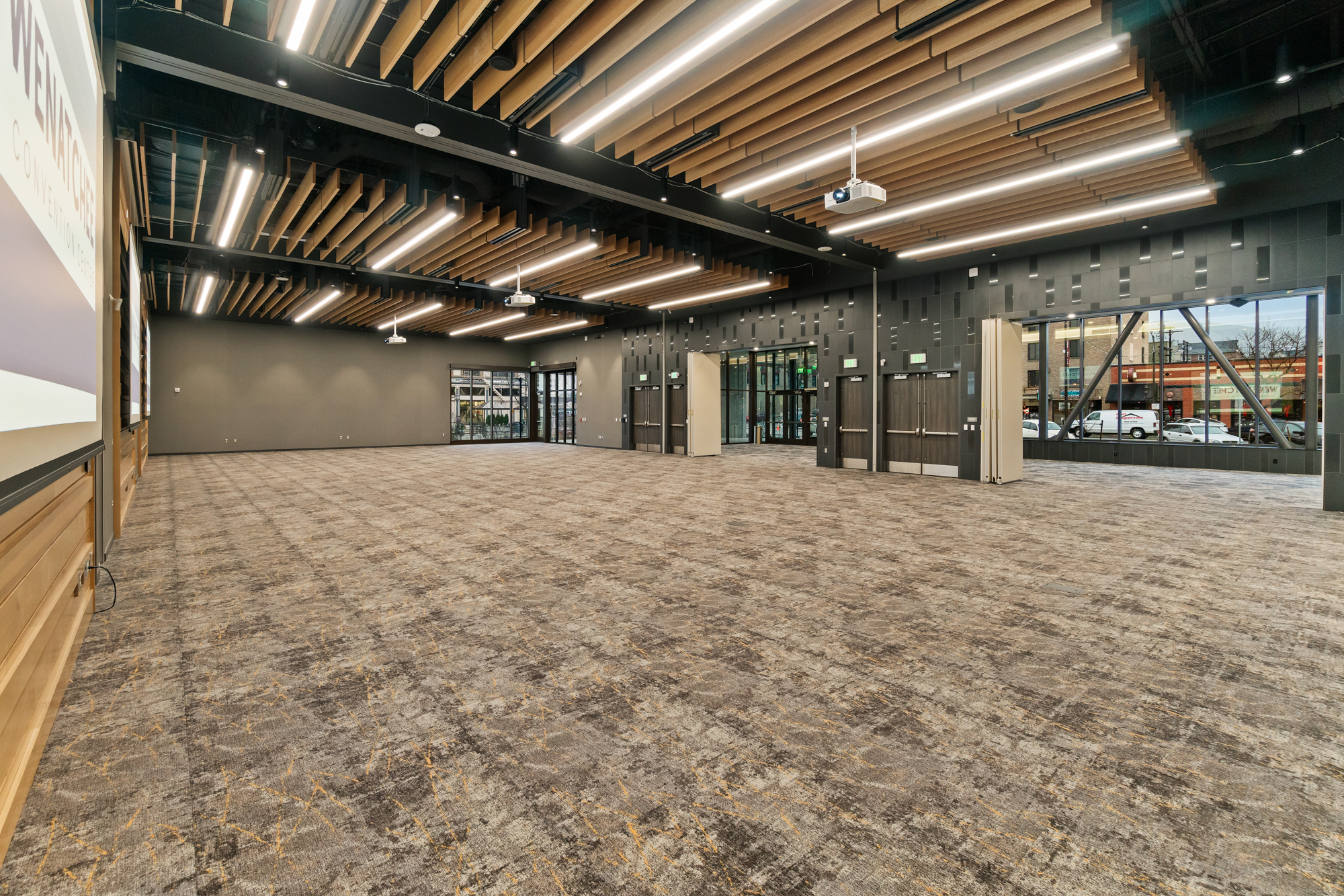 Spacious modern conference room with projectors and lighting.