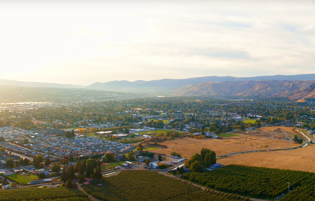 Aerial view of town and surrounding fields at sunset.