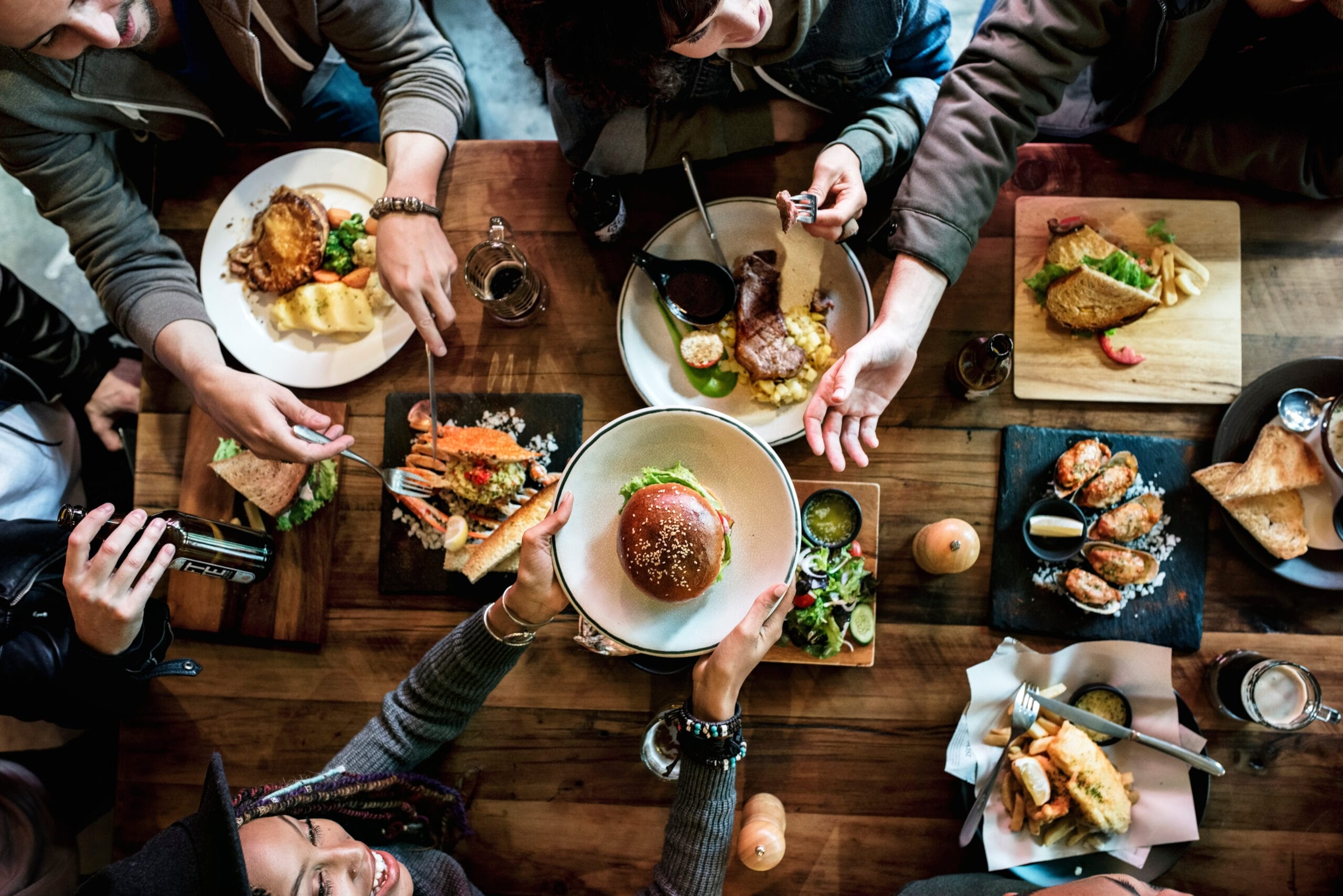 Group of people sharing diverse meals at a table.