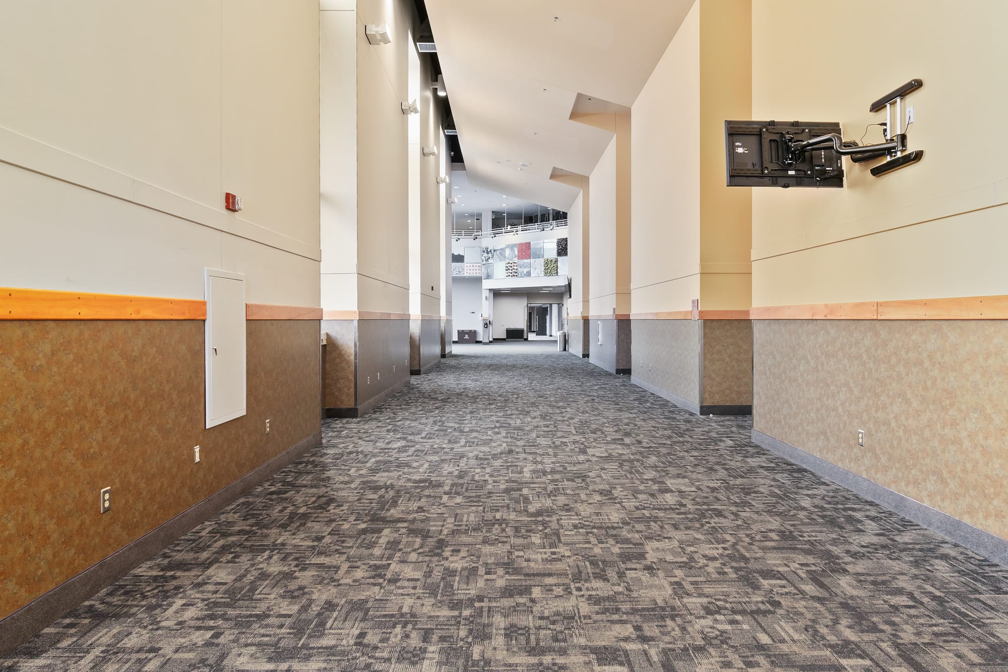 Empty conference hallway with carpet and high ceilings.